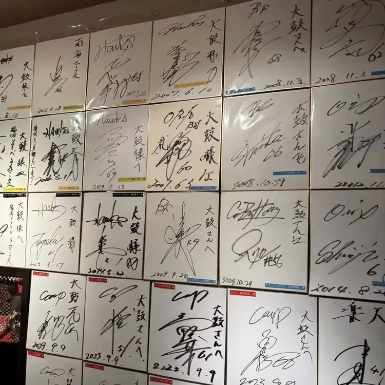 サイン色紙が並ぶ店内の壁